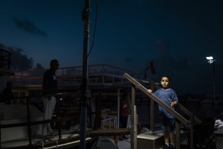 Tyre, Southern Lebanon — June 7, 2026. Displaced people spend the evening in the Christian port area of Tyre. Israeli airstrikes have targeted residential neighborhoods, leaving some areas empty as residents flee within minutes, while others remain, bound to their homes and livelihoods. The escalation between Israel and Hezbollah has displaced more than one million people, deepening an already severe humanitarian crisis and complicating ceasefire efforts. Diego Ibarra Sánchez for NPR