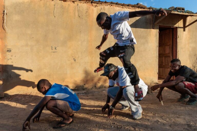 Pastor Billiance Chondwe and the boys play outside their home. Pastor Billy is trying to help 25 newly orphaned children in his community. He regularly visits Joseph, Gift and Alumbwe, who lost their parents to HIV this year.