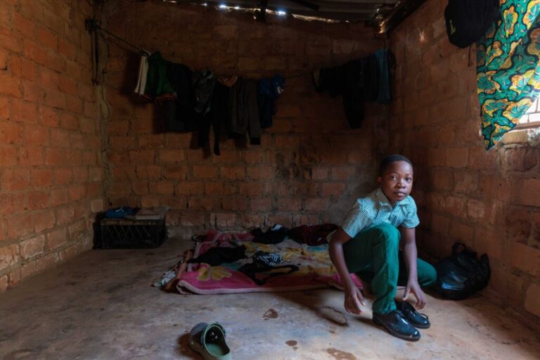 Alumbwe, who's 12 and lives in Zambia, gets ready for school. It's a 2 mile walk from his home. He and his brothers have lived without adult supervision since their parents died of AIDS earlier this year.