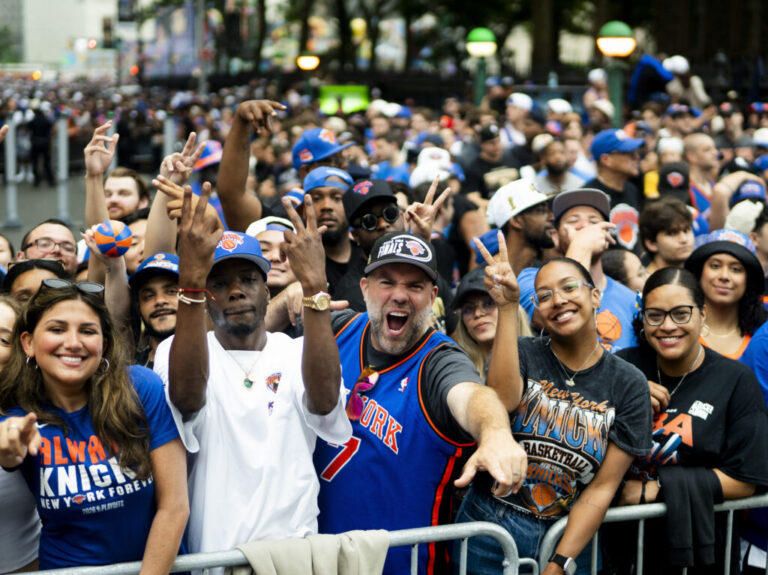 New York Knick fans celebrate winning the 2026 NBA Championship with a ticker tape parade at City Hall.