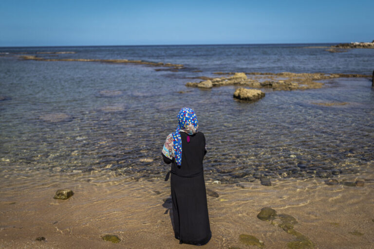 yre, Southern Lebanon — June 7, 2026. Mimi Istanbouli, a displaced schoolteacher, looks out over the sea. Her home was destroyed, and she is sheltering in a theatre with her ill mother. Israeli airstrikes have targeted residential areas in Tyre, leaving entire neighborhoods empty, while others remain, bound to their homes and livelihoods. The escalation between Israel and Hezbollah has displaced more than one million people, deepening an already severe humanitarian crisis and complicating ceasefire efforts. Diego Ibarra Sánchez for NPR