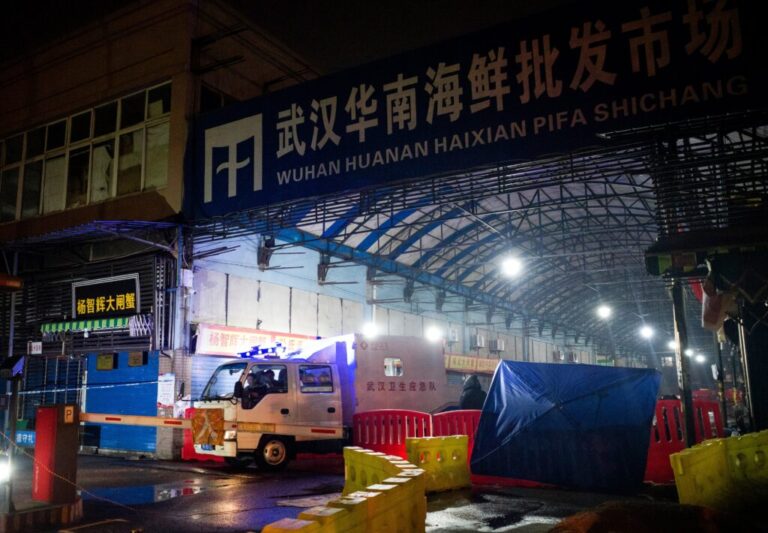 Members of the Wuhan Hygiene Emergency Response Team leave the shuttered Huanan Seafood Wholesale Market in the city of Wuhan, in Hubei, Province on January 11, 2020. Investigations of the origin of COVID-19 have focused on the animals sold at the market.