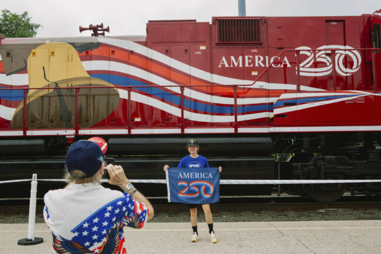 Adam Lapham, 25, of Green, Ohio, stands for a photograph taken by his grandfather, James Wallace, 74, in front of a train car connected to Union Pacific’s Big Boy No. 4014, the world’s largest operating steam engine locomotive, during a stop in Philadelphia.