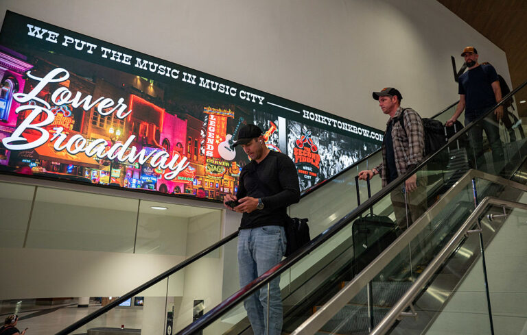 Travelers descend an escalator at Nashville International Airport, which has seen explosive growth over the past decade.