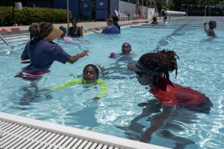 Recreational therapist Tiera Chaney works with Amir Williams, 6, during a recent Swim Buddies session.