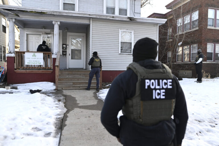 MINNEAPOLIS, MINNESOTA - JANUARY 13: ICE agents approach a house before detaining two people on January 13, 2026 in Minneapolis, Minnesota.