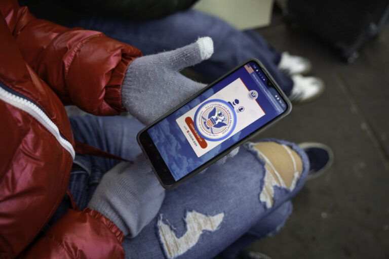 A person tries to use the CBP One app on their phone.