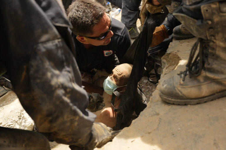 U.S. firefighters from Fairfax County, Va., pull a survivor from the rubble of a building that collapsed in the earthquakes in La Guaira, Venezuela, Sunday.