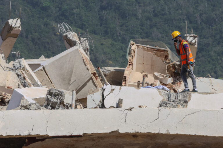 A person searches for victims on June 27 amid debris of a collapsed building after powerful earthquakes struck Venezuela, in Los Corales, Venezuela.