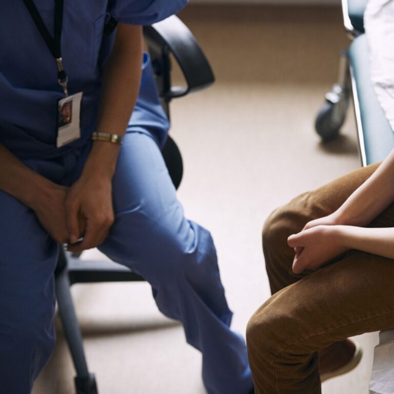 A patient and their doctor are sitting.