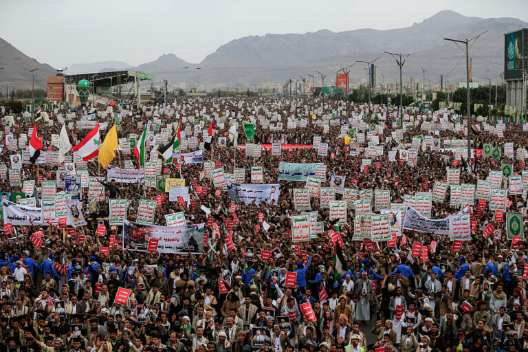 Yemeni supporters of the Houthi movement gather during a rally in Sanaa, Yemen, on July 17. Many people standing in the large crowd are holding up signs.