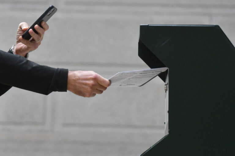 A man photographs himself depositing his ballot in an official ballot drop box in Philadelphia on Oct. 27, 2020.