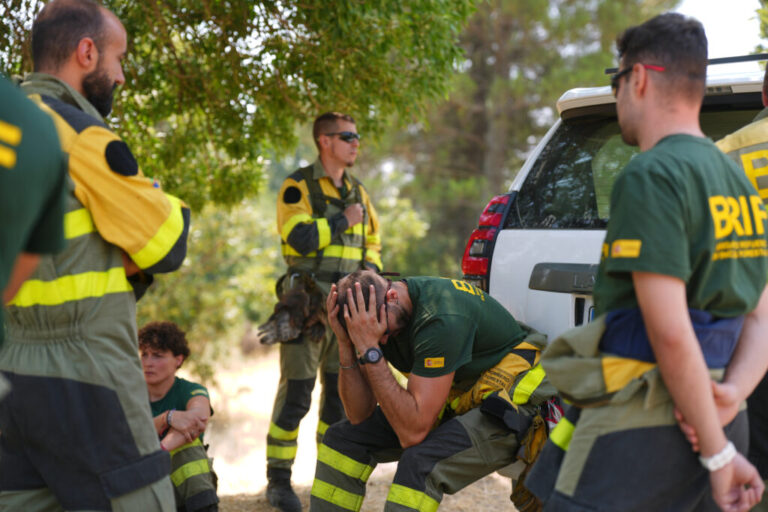Aesir Diaz, 31, a technician with Spain's Forest Fire Reinforcement Brigades (BRIF), center, sits next to teammates during a break from battling a wildfire in Sotillo de Adrada, Ávila province, Spain, as the fire continues to spread, Tuesday, July 28, 2026.