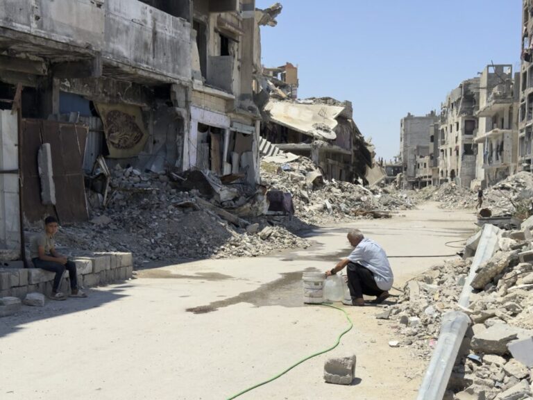 A man fills a jug from from a rigged waterline in al-Shujaiya, but the nearest source of potable drinking water is 30 minutes away.