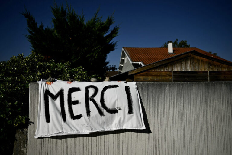 This photograph shows a placard hanging on the wall of a house reading