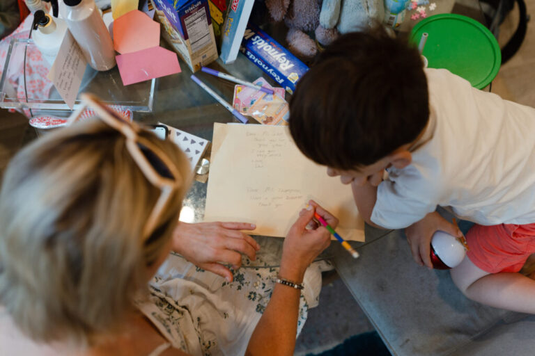 Dani Bensky sits at her kitchen table with her 6-year-old son in New Jersey on June 22. Together, they write notes to give to his teachers on the last day of school before summer break.