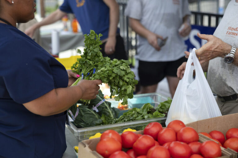 A customer purchases produce at a farmers market in Philadelphia on July 15.