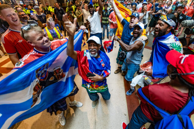 Scottish and Haitian fans dance and chant together inside Boston's South Station while waiting to board MBTA trains to the World Cup match between Scotland and Haiti in Foxborough, Mass., on Saturday, June 13.