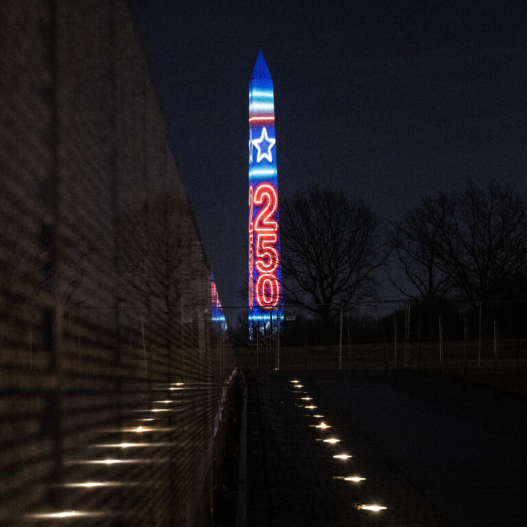 The numbers 250 are projected onto the Washington Monument, as seen from the Vietnam Veterans Memorial, during the