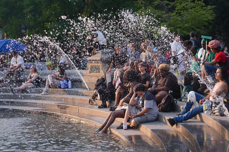 People spend time at Washington Square Park during hot weather in New York City on Monday.