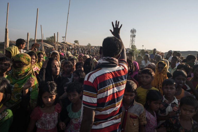 A man gestures telling Rohingya migrants queuing to receive aid that the delivery has been cancelled, at the Kutupalong refugee camp at Cox's Bazar on November 30, 2017.