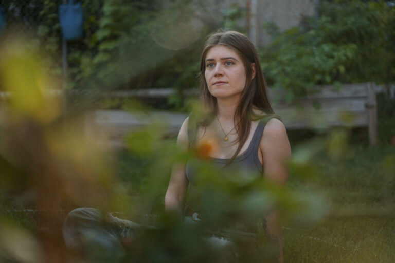Joselyn Walsh, a musician, sits for a portrait at her home on July 30, 2026, in Chicago, Ill. Walsh was charged with federal conspiracy following a 2025 ICE protest, but the charges were later dismissed after alleged prosecutorial misconduct.