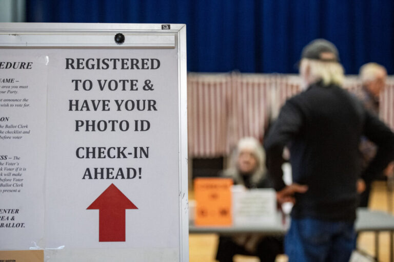 A sign informs registered voters to have their photo IDs ready to check in at a polling place in Lancaster, N.H., in 2024.
