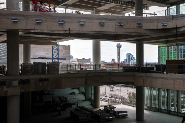 The iconic Reunion Tower is seen through construction of the new Goldman Sachs campus in Dallas. The New York investment bank plans to open the 800,000-square-foot project in 2028, with space to eventually employ more than 5,000 local workers.