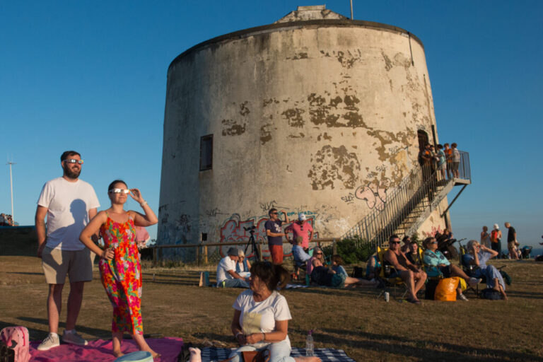 People gather to view the partial solar eclipse near Martello Tower 3 in Folkestone, England.