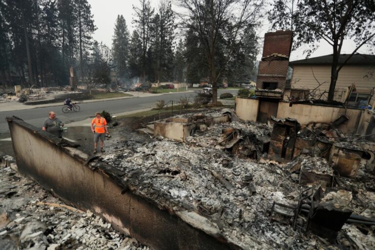 Chris Mutton, left, whose house burned in a wildfire speaks with Shane Maggart on Aug. 2, 2026, in Spokane, Wash.