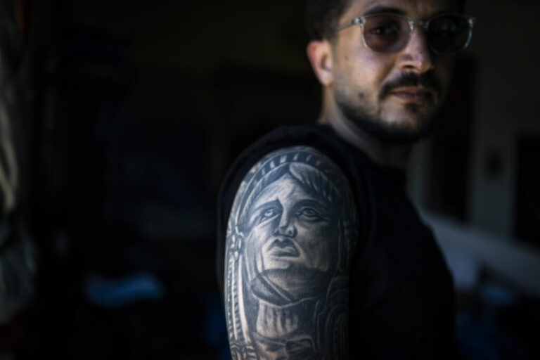 Ali Rida, a member of the Nabatiyeh paramedic team, poses for a portrait. He has a full-sleeve tattoo depicting characters from the movie The Godfather and the Statue of Liberty.