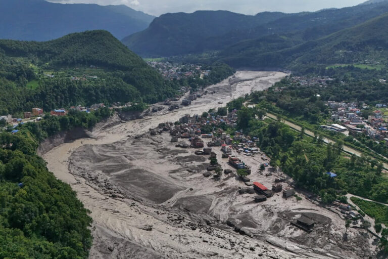 Damaged houses stand precariously near the swollen, debris-choked banks of the Trishuli River after flash floods in Nepal's Nuwakot district on Wednesday.