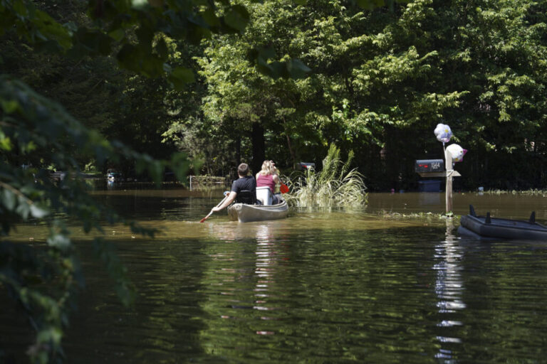 Residents paddle through a flooded neighborhood in a kayak in Indianapolis, Sunday, Aug. 16, 2026.