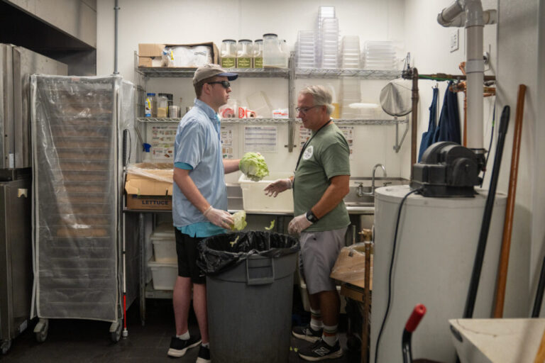 Cody works in the back of Jersey Mike's Subs bopping lettuce, his favorite job, while Next Step's Colin Sabia looks on.