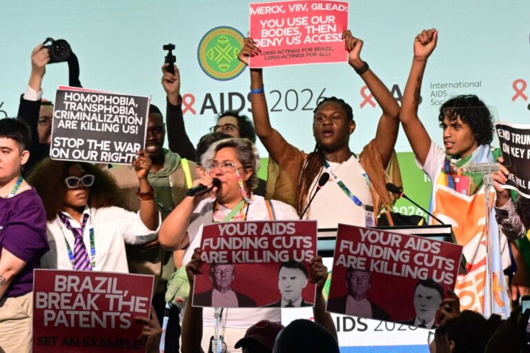 Protesters hold signs, including ones that say