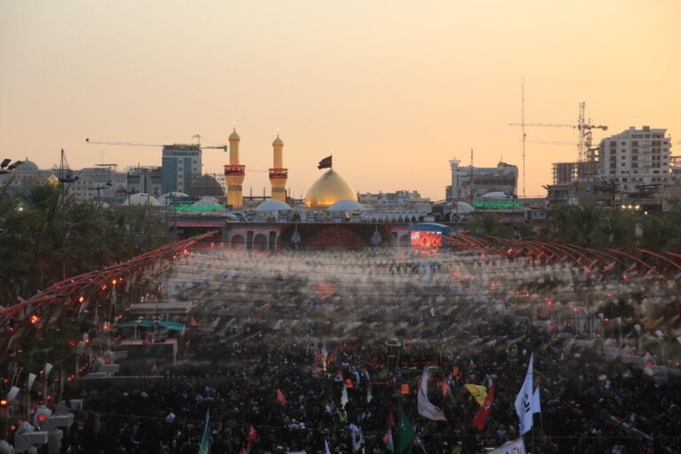 Large crowds of pilgrims fill the area between the two holy shrines in Karbala at sunset