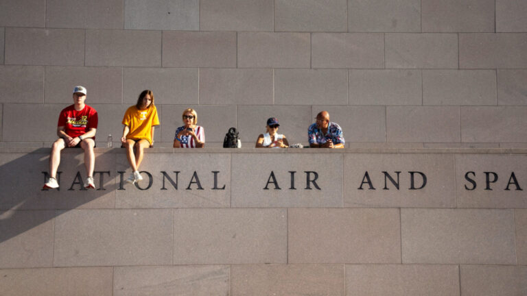 Fans look on from the National Air and Space Museum near the fan zone ahead of the Freedom 250 Grand Prix auto race.