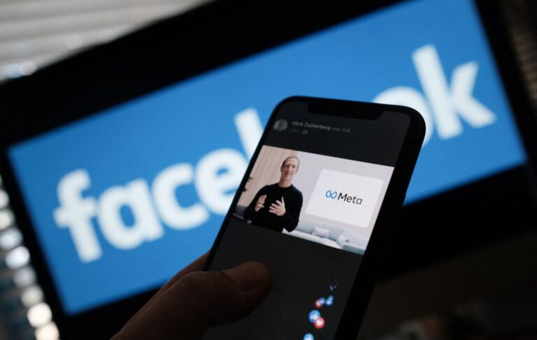 In this illustration photo taken in Los Angeles on October 28, 2021, a person watches on a smartphone as Facebook CEO Mark Zuckerberg unveils the Meta logo.