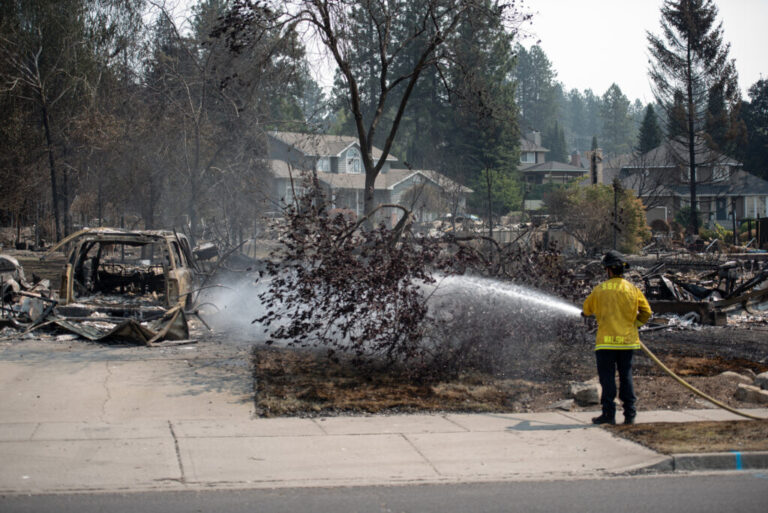 A firefighter puts out a hot spot to prevent new blazes on August 6, 2026 in Spokane, Wash.