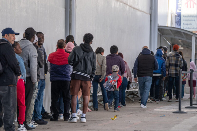 Asylum seekers queue at the entrance of Mexico's Refugee Help Commission and UNHCR offices in Tijuana, Mexico on January 24, 2025. (Photo by Guillermo Arias / AFP) (Photo by GUILLERMO ARIAS/AFP via Getty Images)