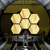 Ernie Wright stands near the James Webb Space Telescope mirrors as they sit just outside the testing chamber in the x-ray calibration facility at MSFC.