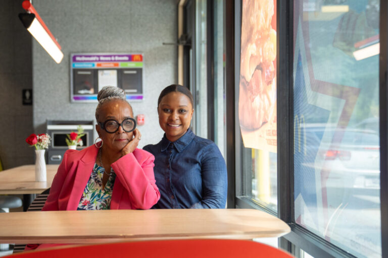 Mary Hopkins Navies (no hyphen) and her daughter Imani Ford sit at a table inside one of the McDonald's restaurants they own in Prince George's County, Md.