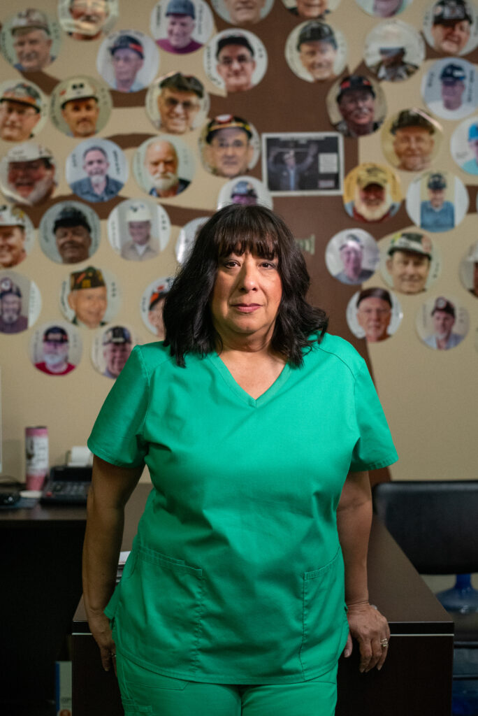 Wearing green scrubs, respiratory therapist Marcy Freeman stands at her clinic in Norton, Virginia.