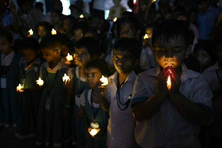 School students hold LED candles as they gather to pay their homage to people who died in Nepal's flash flood, in Chennai.