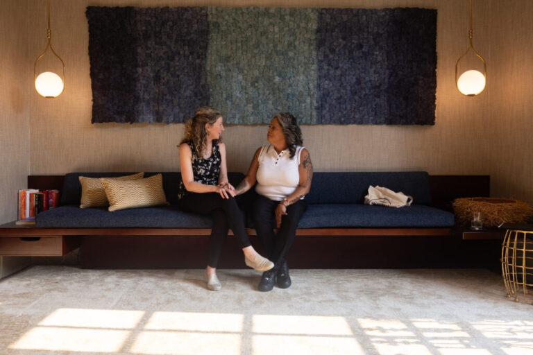 Sudbury (left) and Mireles chat before a fundraiser for Rasa in Washington, D.C. Both women are seated on a long couch.