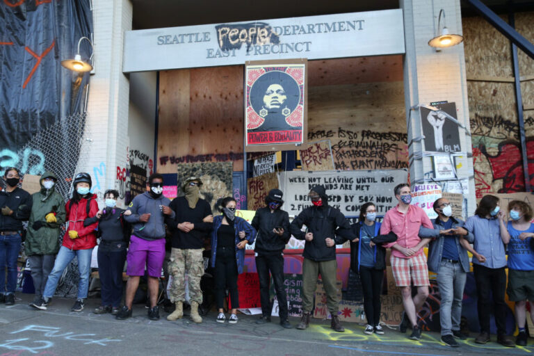 CHOP demonstrators link arms outside the East Precinct of the Seattle Police Department.