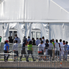 Migrant children line up to enter a tent at the Homestead Temporary Shelter for Unaccompanied Children in Homestead, Fla. in February 2019.