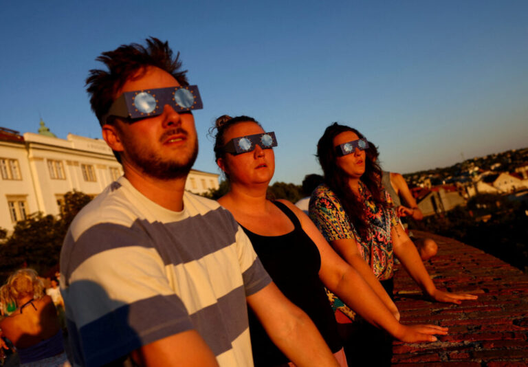 People wear protective glasses to observe a partial solar eclipse in Budapest, Hungary.