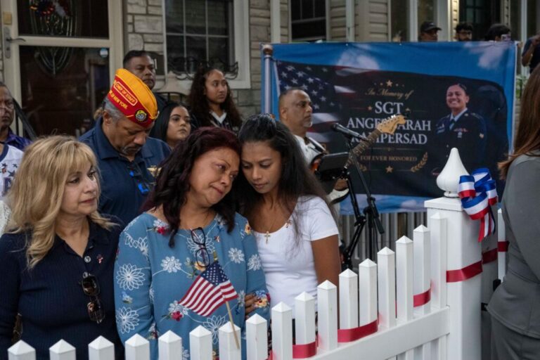 Family of Sgt. Angel Sarah Rampersad, aunt Judy Rackal, left, mother Carol Acevedo, center, and sister Laura Tamby, right, attend a candlelight vigil outside her home in Ozone Park, Monday, July 27, 2026, in the Queens borough of New York.