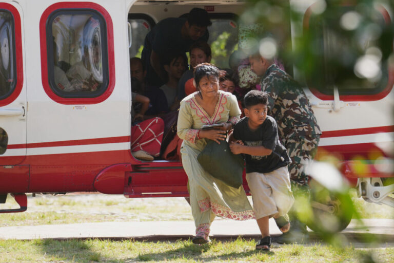 Army soldiers help a family disembark from a helicopter after they are rescued from an area affected by flash flooding in Nepal's Nuwakot district, Friday, Aug. 28, 2026.